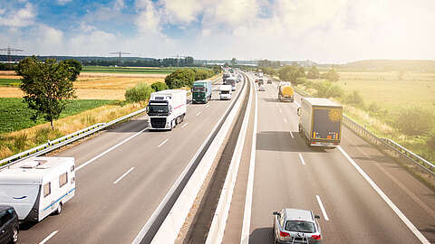 Bild einer Autobahn in ländlicher Gegend mit sonnigem Wetter