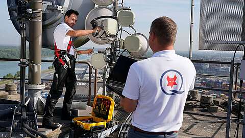 Techniker installieren Funktechnik auf Firmengebäude